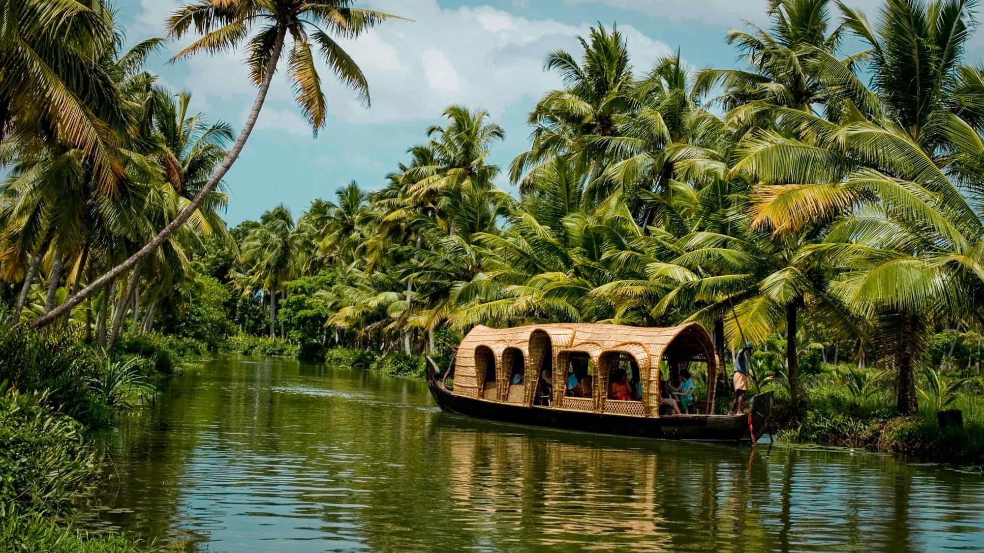 A houseboat on a palm-lined backwater in Kerala